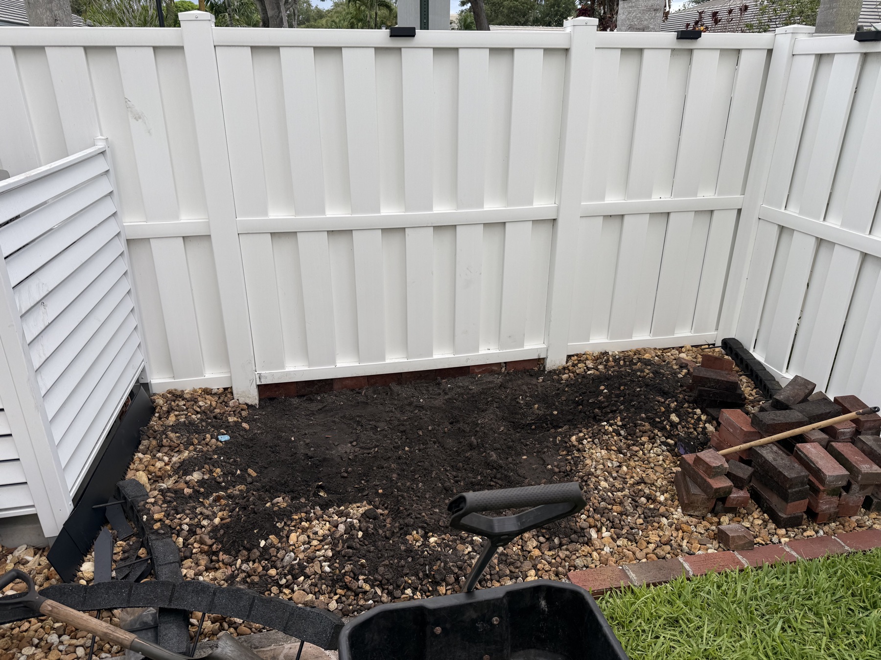 Dead, dug-up dirt corner of the backyard before the makeover, next to the AC unit